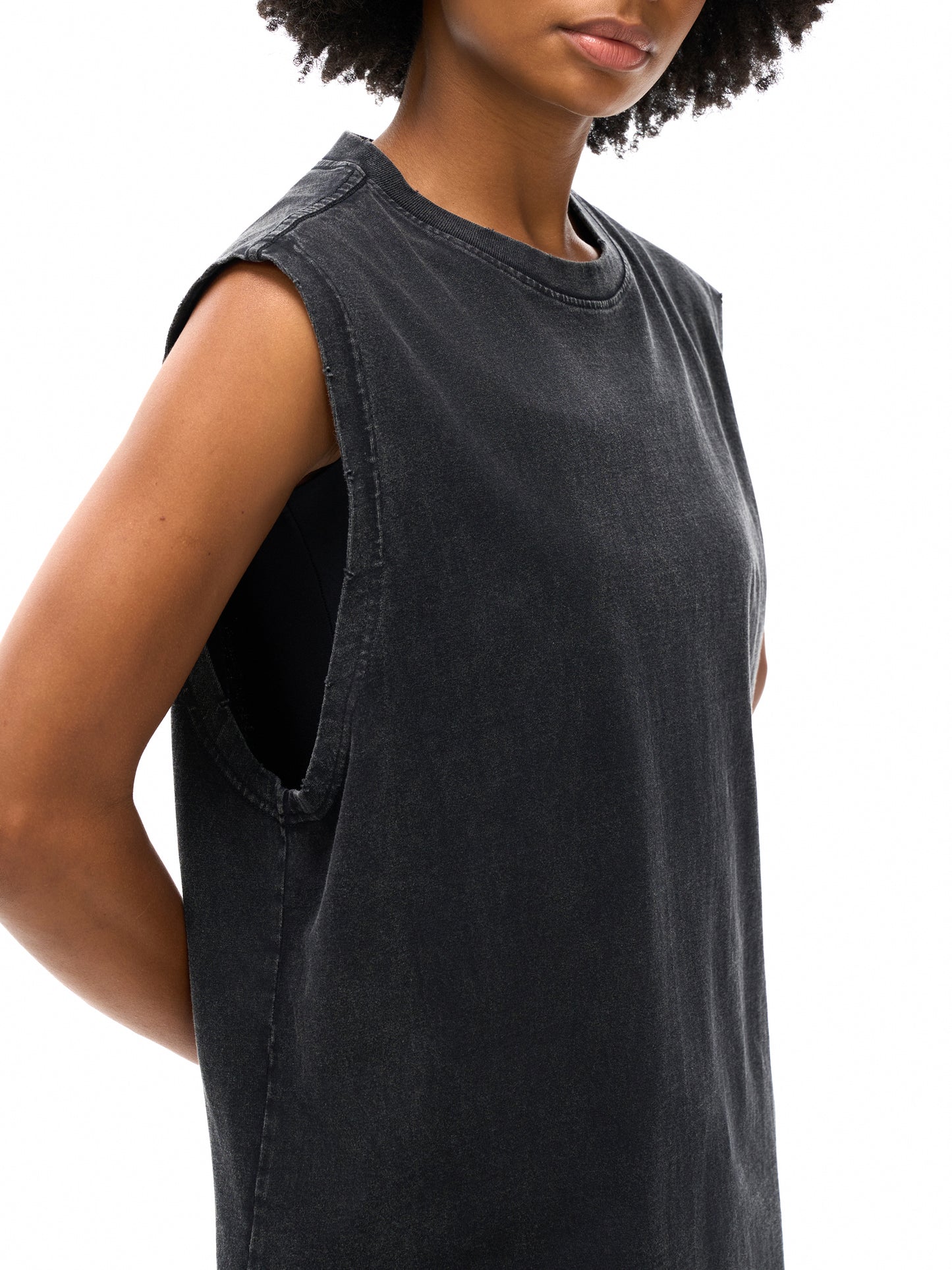 Person wearing a black sleeveless dress on a white background